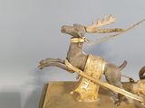 a gold clock with a reindeer pulling a sleigh on it