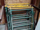 une pile de chaises vertes et jaunes devant un immeuble