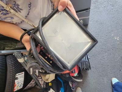 une personne tenant une lampe à la main, posée par terre