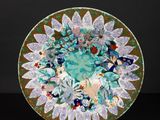 a green plate with flowers and leaves on it