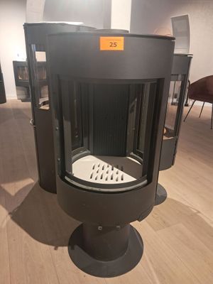 un poêle noir posé sur un plancher en bois dans une pièce