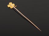 a close up of a person holding a wooden stick with a flower on it