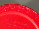 a red plastic bowl with a red lid on a table