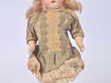 a small doll that is standing on a white surface
