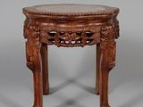 une vieille table en bois avec un plateau en marbre et des pieds sculptés