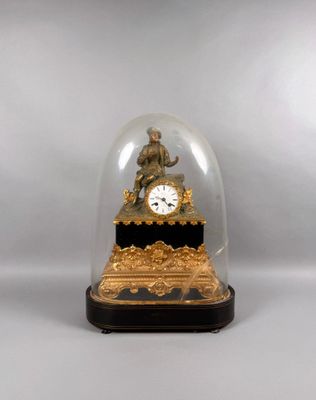 a gold clock under a glass dome on a table
