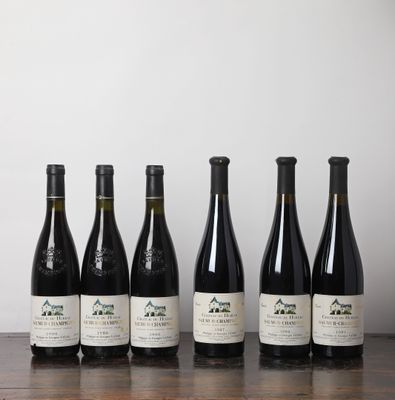 six bouteilles de vin alignées sur une table devant un mur blanc