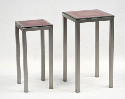 une paire de tables d'appoint en métal et en verre sur fond blanc