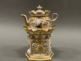 a white and gold teapot with a crown on top of it
