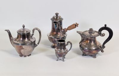 trois théières et une cafetière en argent sur une surface blanche