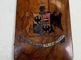 a wooden plaque with a picture of a coat of arms on it
