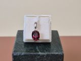 a close up of a ring with a red stone in it