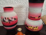 three vases sitting on a table next to a fan