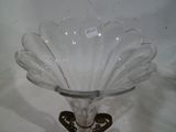 un vase en verre transparent avec une base en métal sur une table