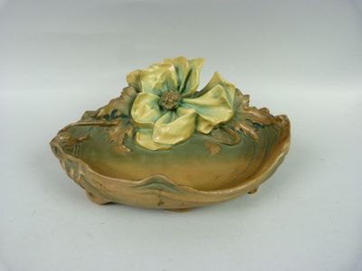 un petit bol orné d'une fleur, posé sur une table