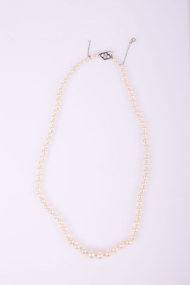 un collier de perles blanches avec un fermoir en argent sur fond blanc