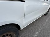 a small white car with a flat tire on the street
