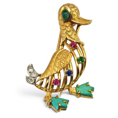 a close up of a gold bird brooch with multi colored stones