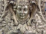 a silver clock with a face on it on a table