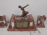 a statue of a man holding a tennis racquet on top of a clock