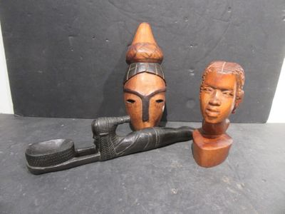 pair of carved wooden african masks and a pipe tobacco holder