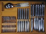 a wooden drawer with silverware and utensils in it