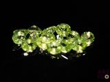 some very pretty green diamonds sitting on top of a black surface