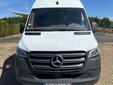 a white van parked in a parking lot with a blue sky in the background