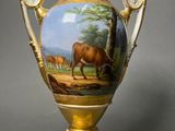 a vase with a painting on it on a stand