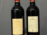 two bottles of wine sitting on a table next to each other
