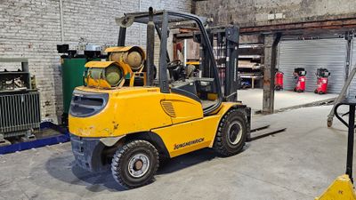 un chariot élévateur jaune garé dans un entrepôt