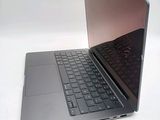 a silver laptop with a black keyboard on a white surface