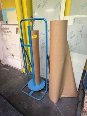 un chariot avec un rouleau de papier kraft à côté d'un autre rouleau de papier kraft
