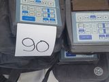 deux appareils électroniques posés sur un sac posé par terre