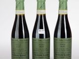 trois bouteilles de vin posées les unes à côté des autres sur une surface blanche