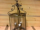 une lanterne en verre contenant une bougie, posée sur une étagère en bois