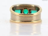 an image of a gold ring with a green stone in it
