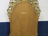 a wooden mirror sitting on the floor next to a wall