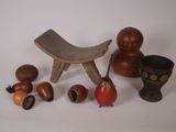 un petit tabouret en bois, un bol et d'autres objets posés sur une table