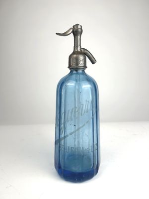 a blue glass bottle with a metal pump on top of it