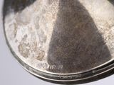 a close up of a silver plate with a pyramid design on it
