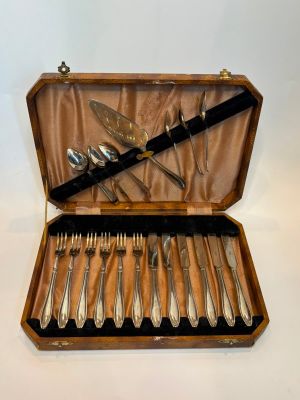 a wooden case with silverware in it on a white surface