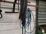 a picture of a garage with tools and a hose hanging on the wall