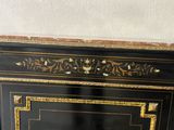 a black cabinet with gold trim and a marble top