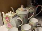 many cups and saucers sitting on the counter