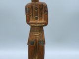 une statue en bois d'un homme avec un chapeau sur la tête