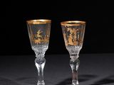 pair of crystal goblets with gold rims on a black background