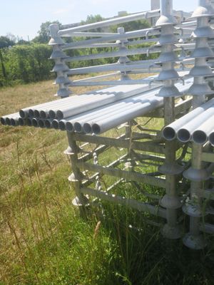 a bench made out of metal pipes in the grass