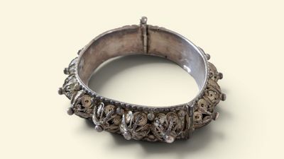 une image montrant un gros plan d'une bague en argent posée sur une surface blanche