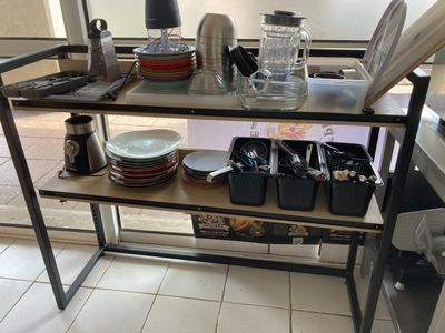 un chariot de cuisine sur lequel sont posés de la vaisselle et des ustensiles